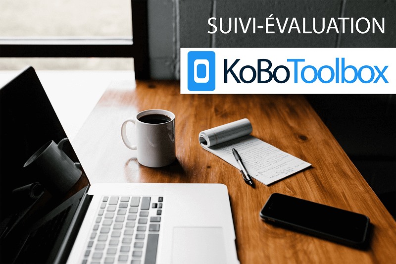 photo d'un bureau avec un ordinateur portable, un mug de café, un smartphone, un bloc notes et le logo KoBoToolbox en haut à droite de l'image